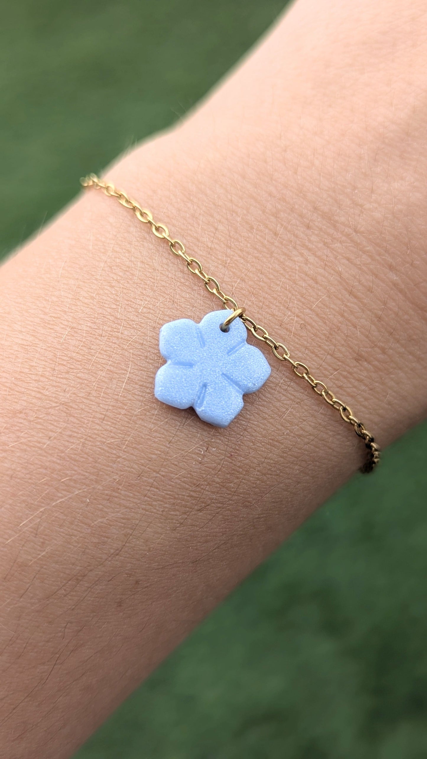 bracelet chaine dorée fleur bleu nacrée au poignet