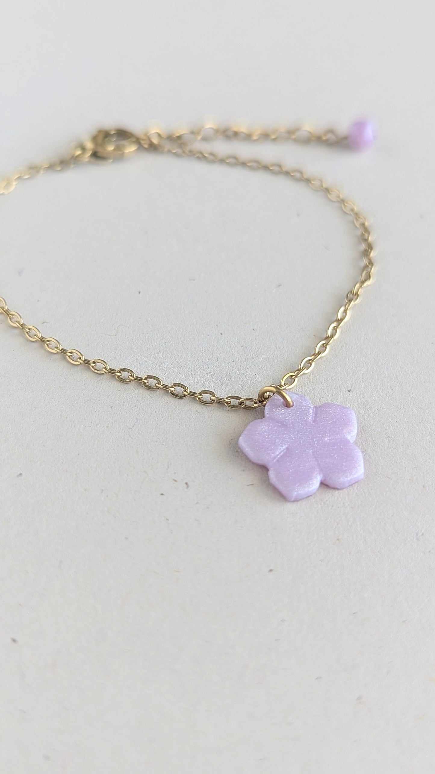 Bracelet doré pendentif fleur violet nacrée