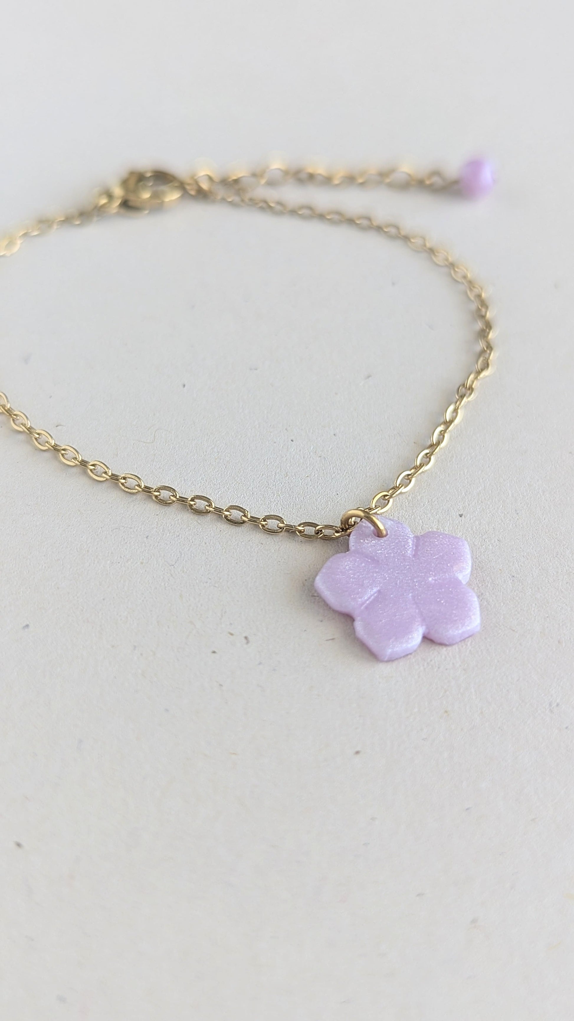Bracelet doré pendentif fleur violet nacrée