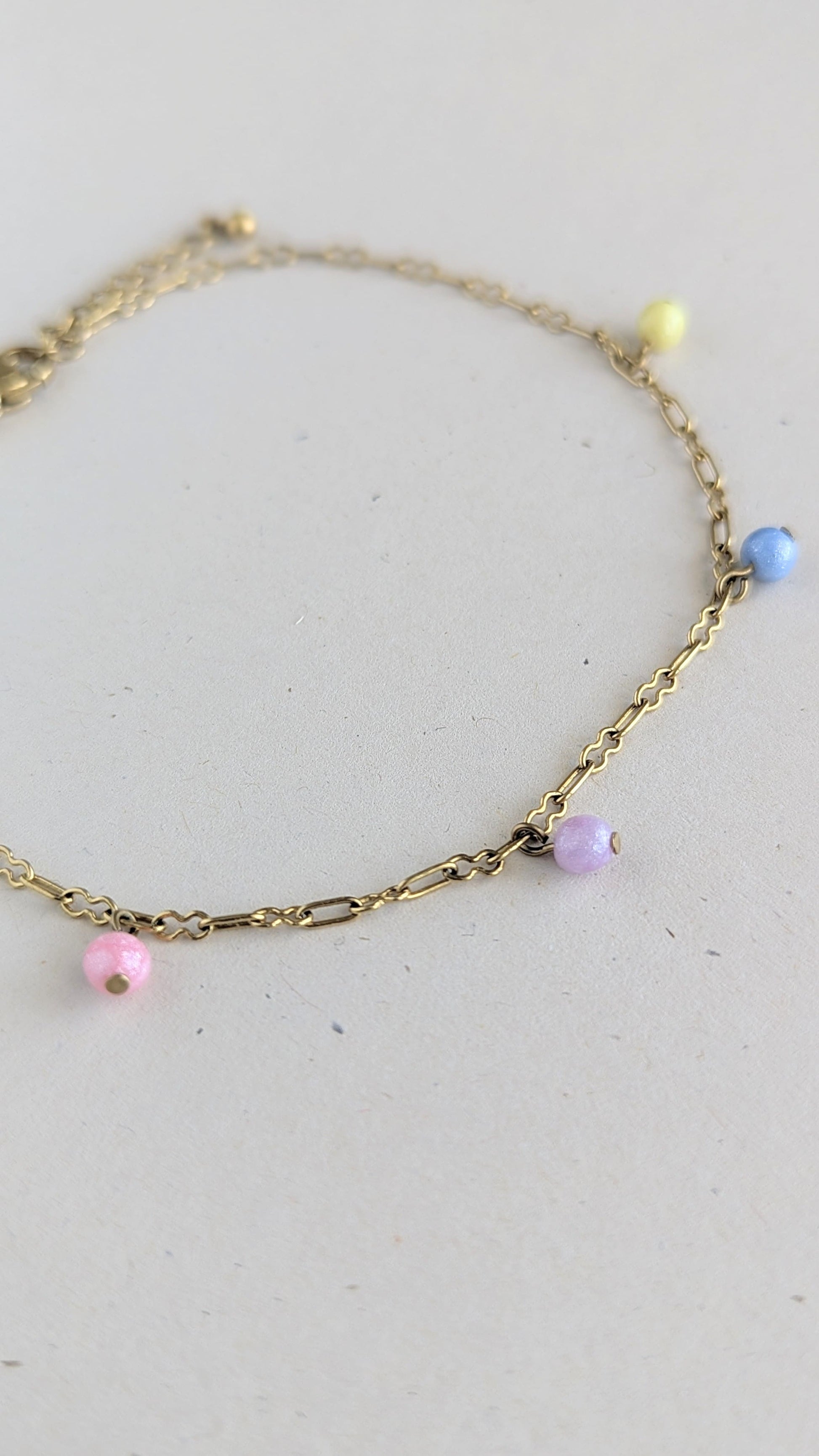 chaine de cheville dorée avec 4 perles colorées